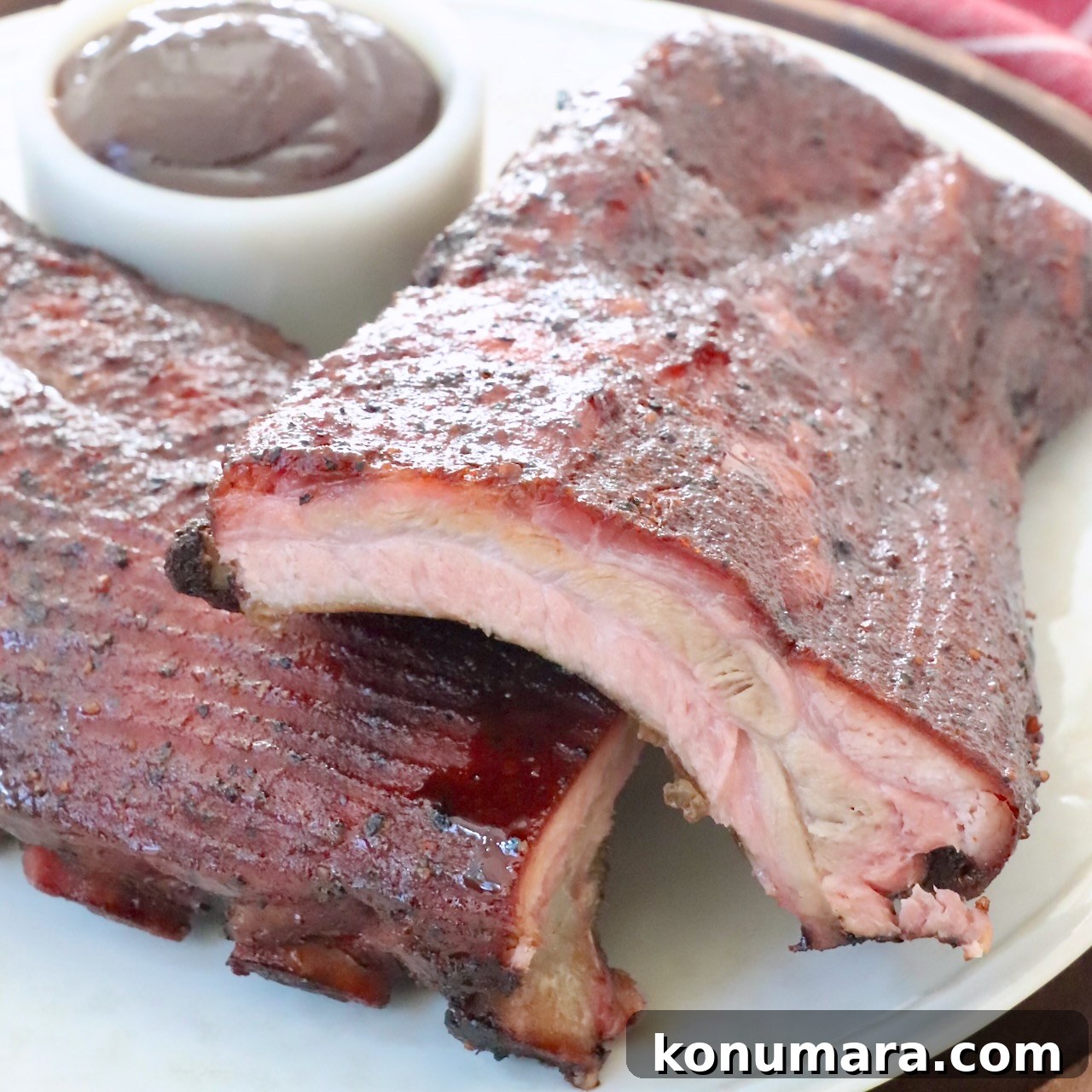 smoked baby back ribs stacked up on plate