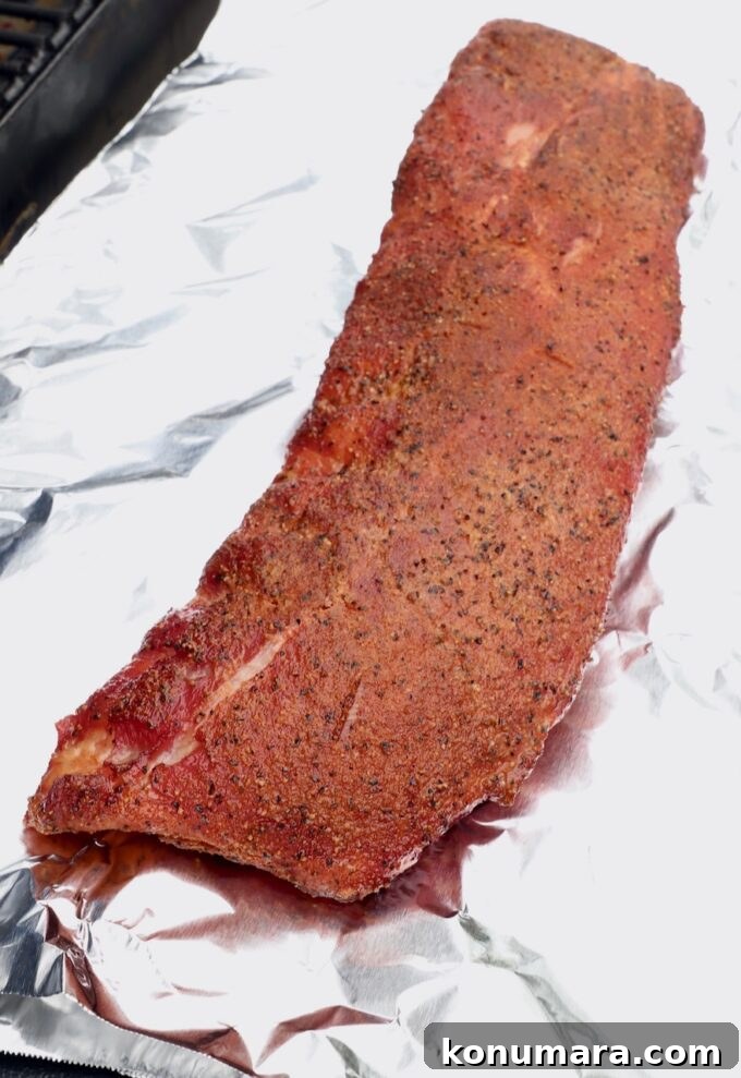 smoked baby back ribs on a piece of foil in a smoker