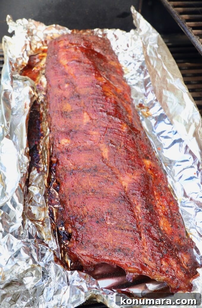 smoked baby back ribs on a piece of foil in a smoker