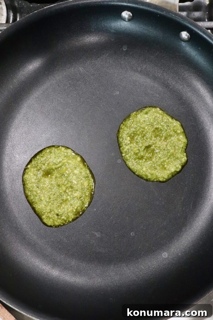 Creamy Pesto Scrambled Eggs with Parmesan 6 two scoops of basil pesto in skillet