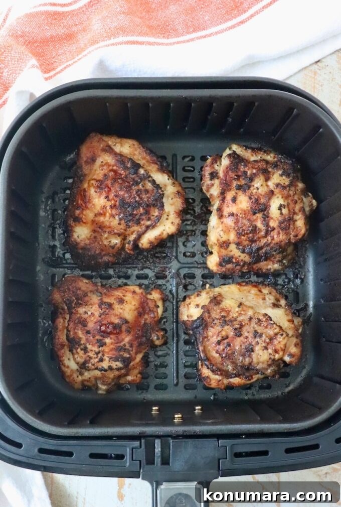 Crispy Garlic Air Fryer Chicken Thighs Recipe 7 cooked bone-in chicken thighs in air fryer basket