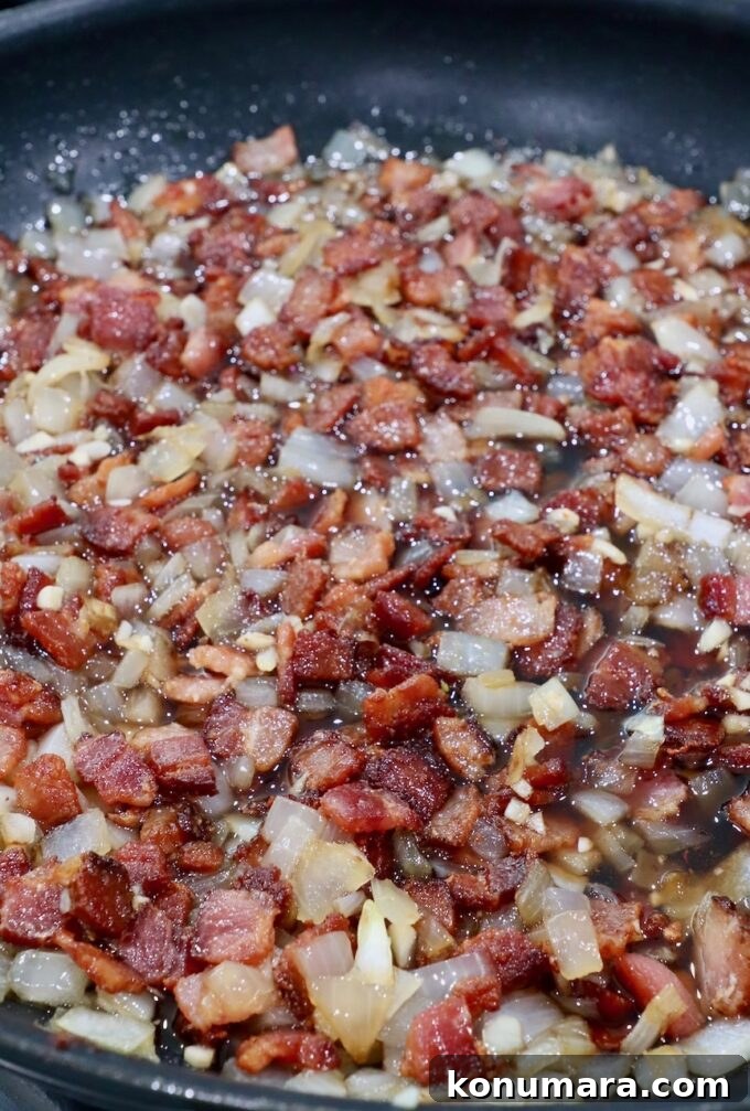 Diced cooked bacon and onions in a skillet