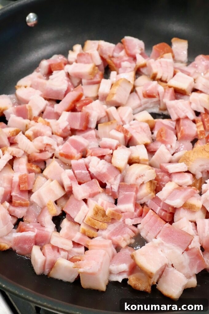 Diced uncooked bacon in a skillet