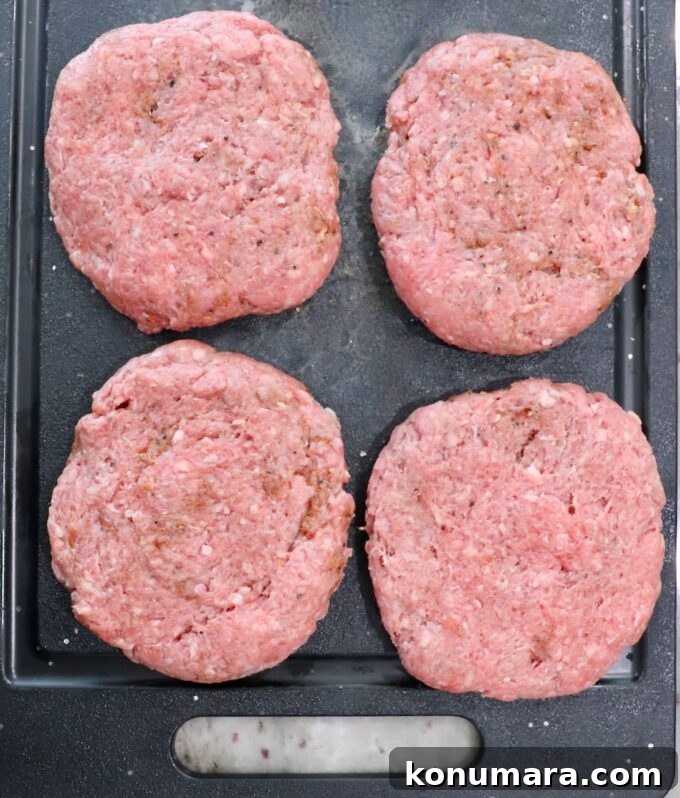 seasoned burger patties on cutting board