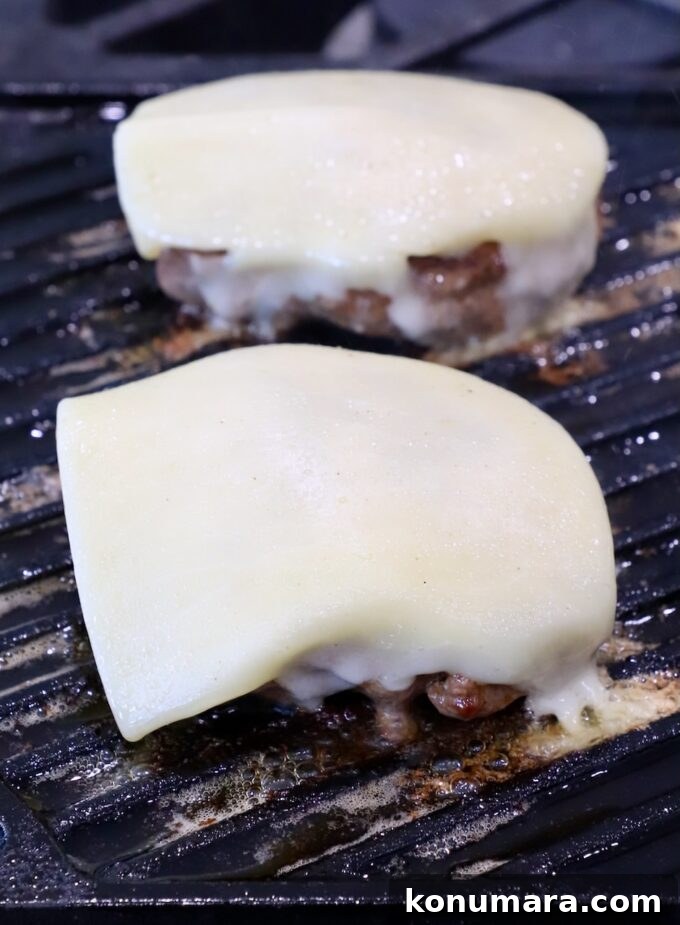 cheese topped burger patties on grill pan