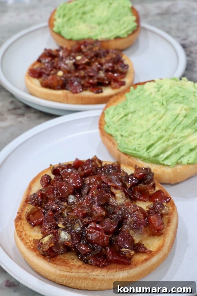 hamburger buns on plates topped with smashed avocado and bacon jam