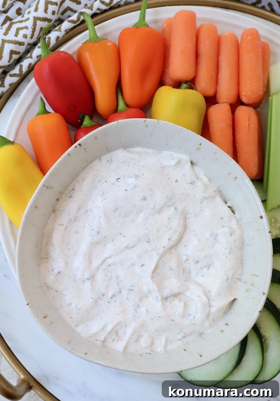 creamy vegetable dip in a bowl surrounded by fresh vegetables
