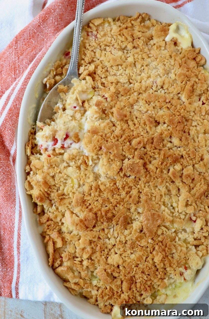 baked squash casserole in baking dish with serving spoon
