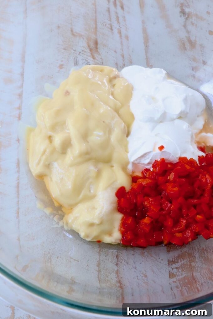 cream of chicken soup, sour cream and pimentos in glass bowl