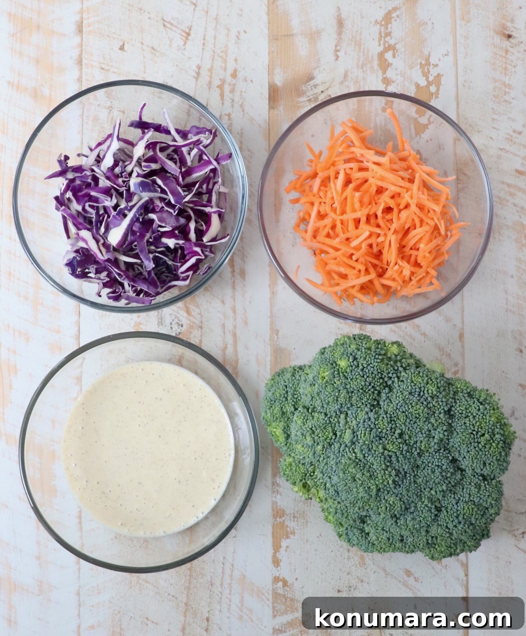 Crunchy Broccoli Slaw Recipe with Creamy Dressing 3 ingredients for broccoli slaw on white wood board