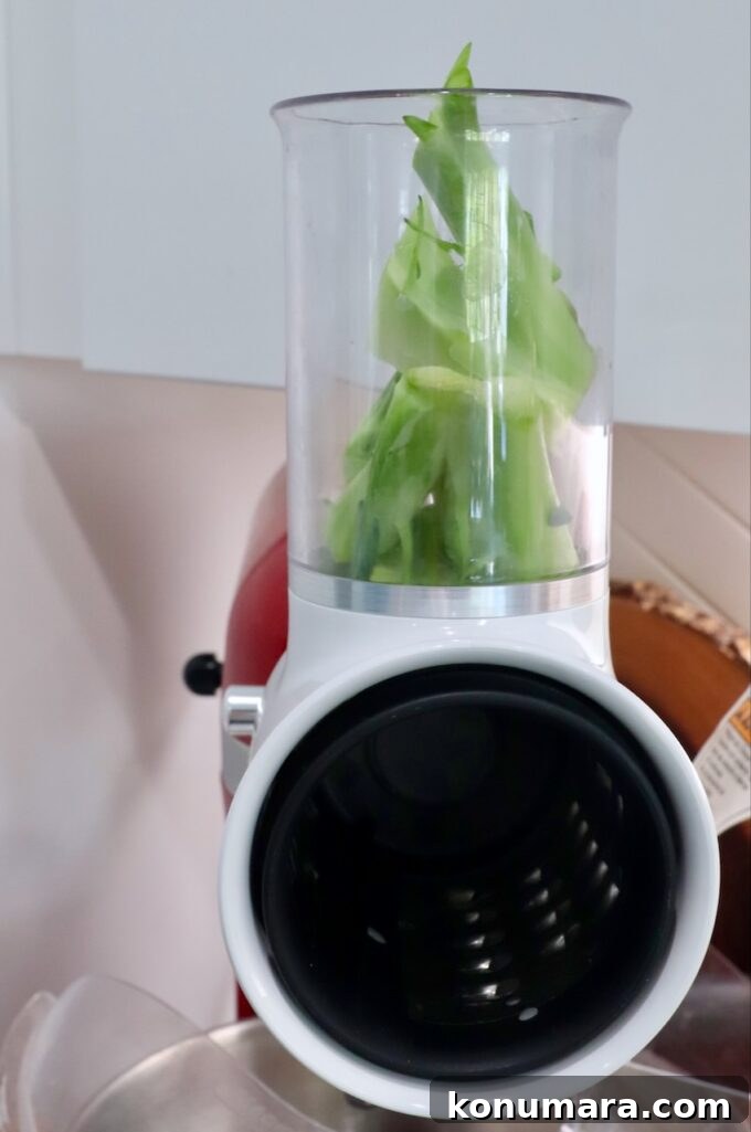 Crunchy Broccoli Slaw Recipe with Creamy Dressing 5 broccoli stems in shredding attachment on kitchenaid mixer