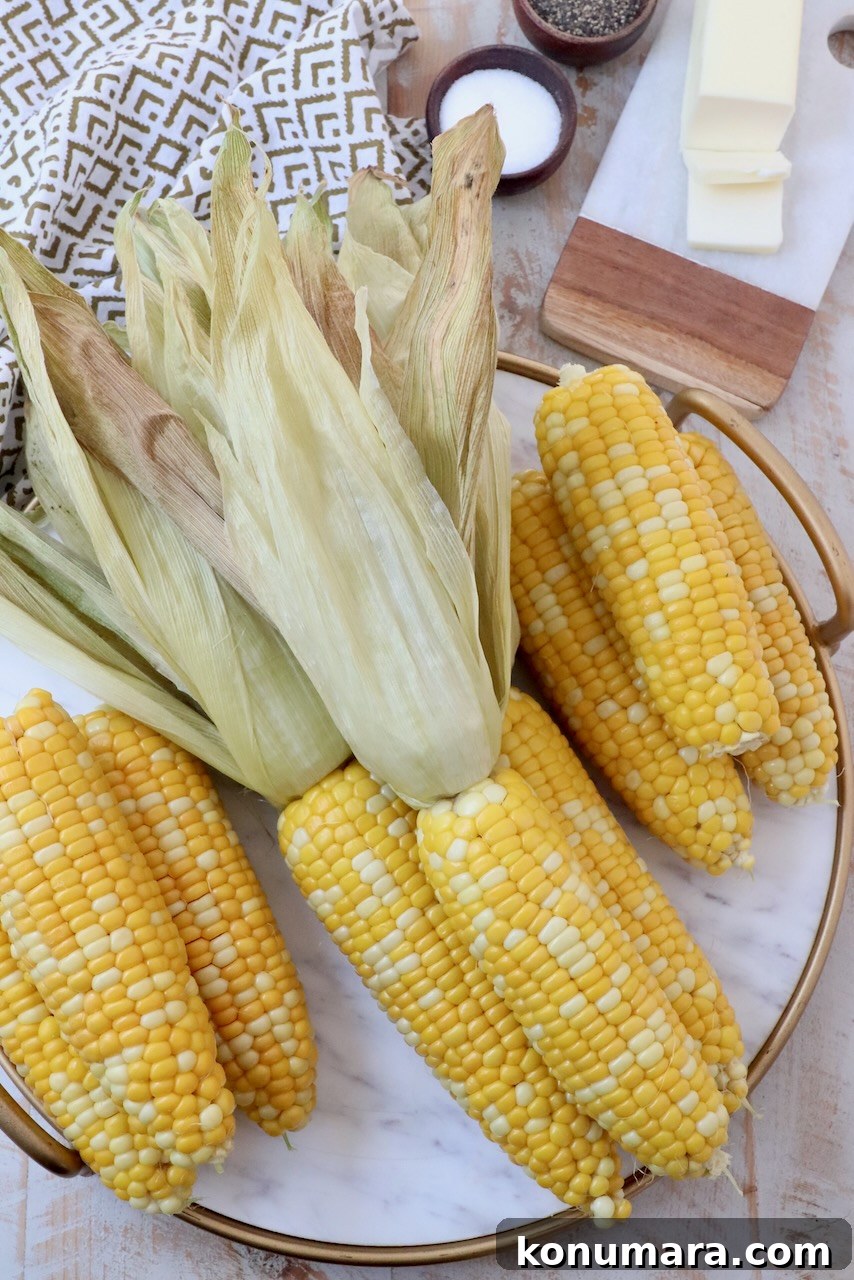 Cooked corn on the cob on marble serving tray