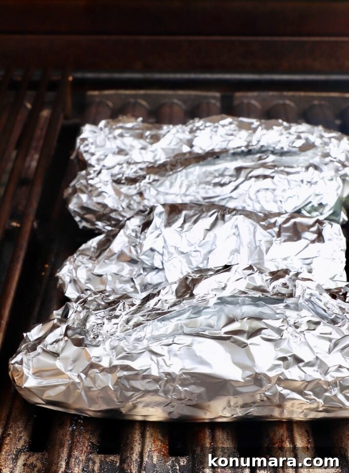 Foil wrapped corn on the cob on grill