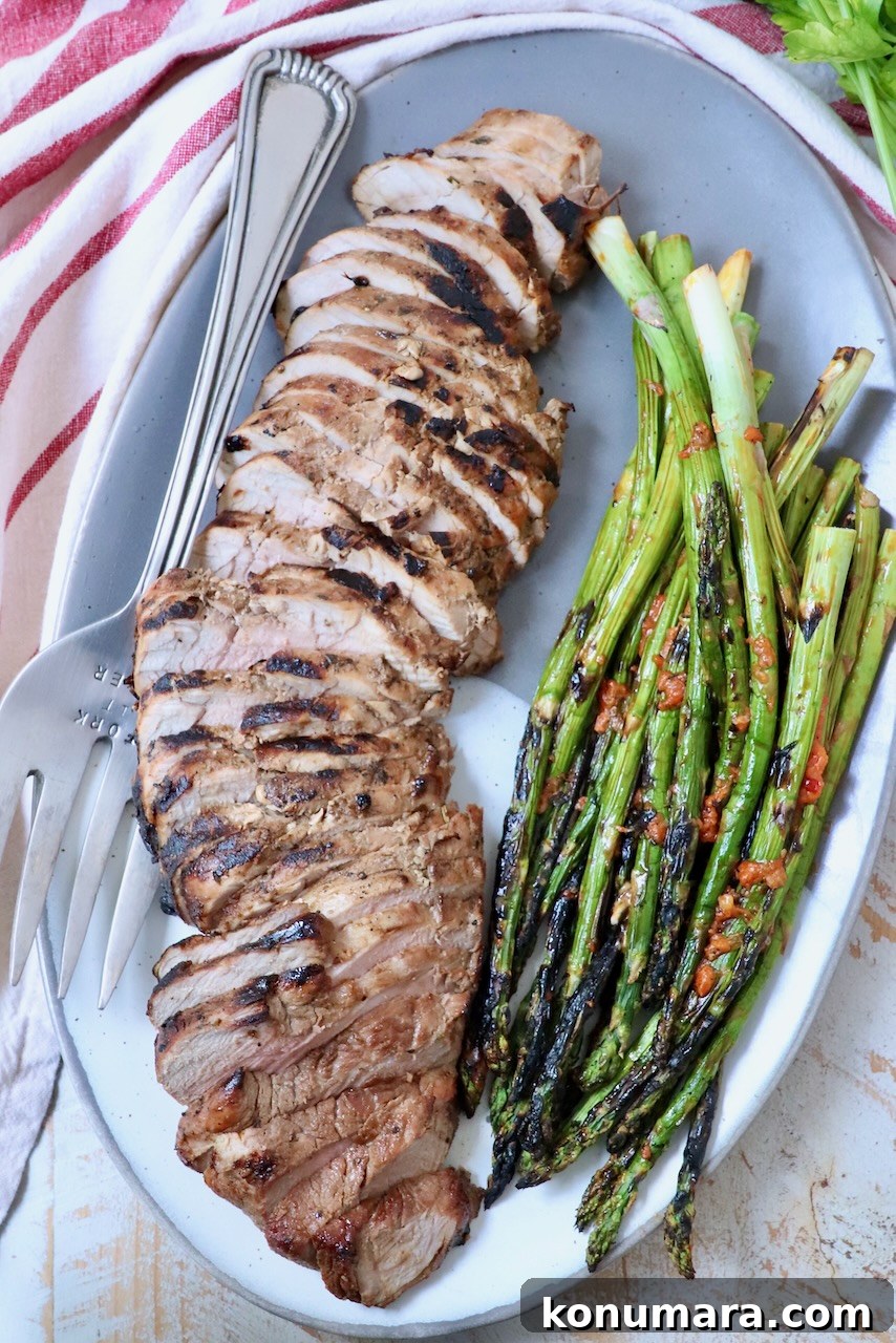Savory Pork Tenderloin Marinade for Tender, Juicy Meat 10 sliced pork tenderloin on plate with grilled asparagus