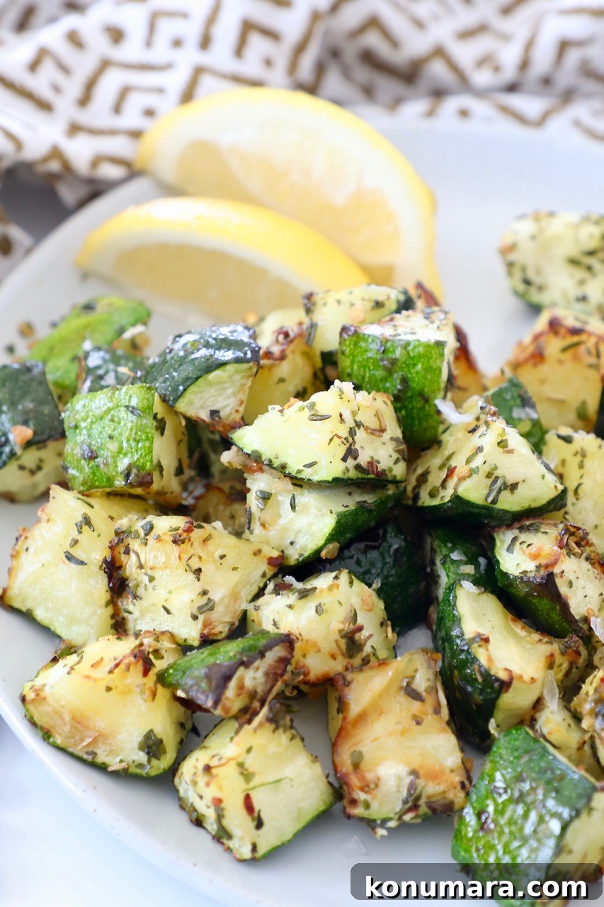 How to Cook Zucchini: Roast, Saute, Grill, Stir-Fry 2 seasoned cooked diced zucchini on plate with lemon wedges