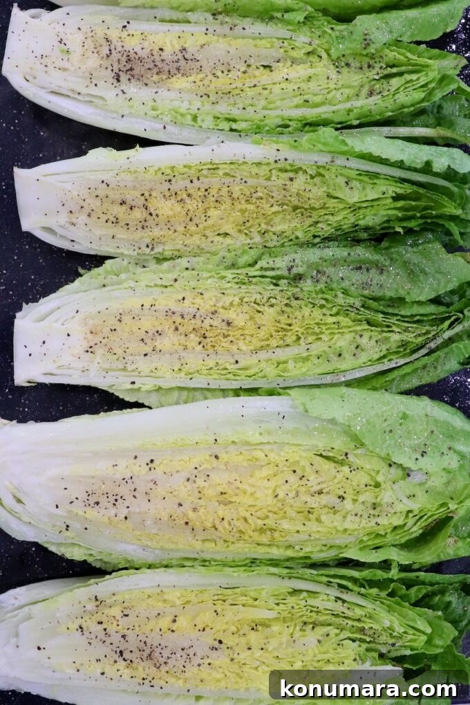 Grilled Caesar Salad with Charred Romaine and Garlic Croutons 12 seasoned romaine lettuce hearts cut in half and seasoned on cutting board
