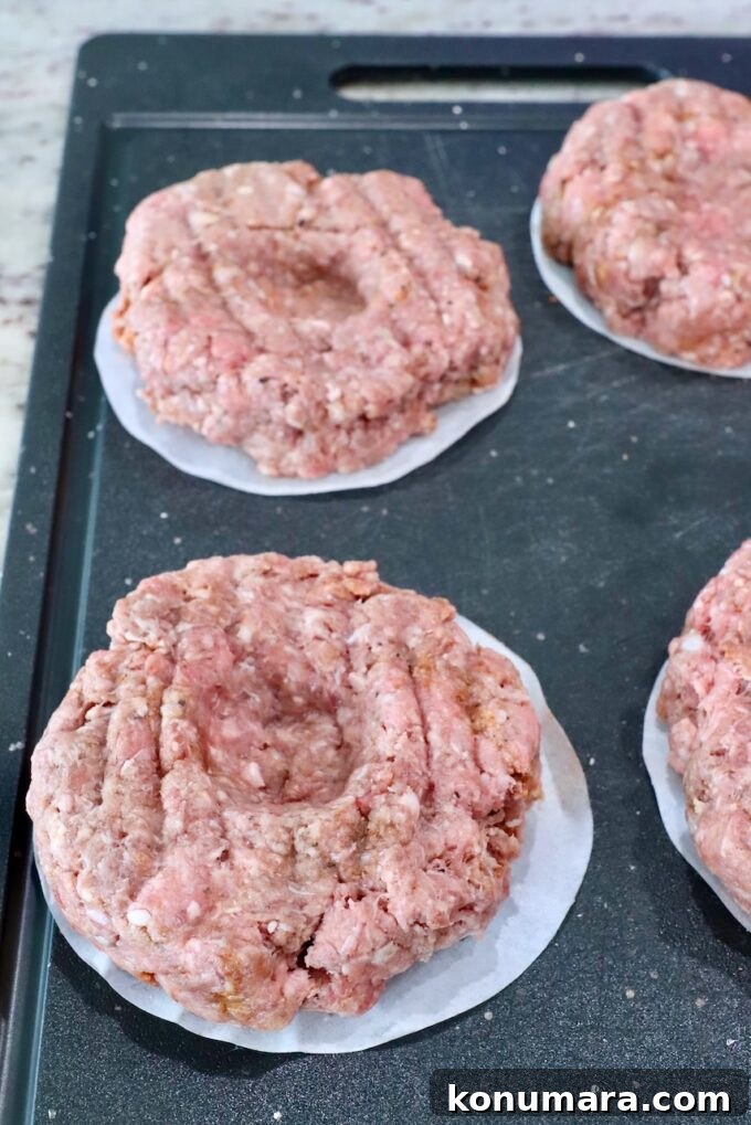 burger patties with indentation in the middle on a cutting board