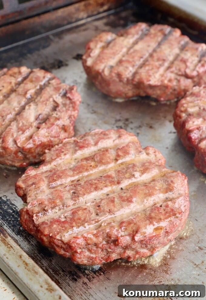 smoked burger patties on a flat top griddle