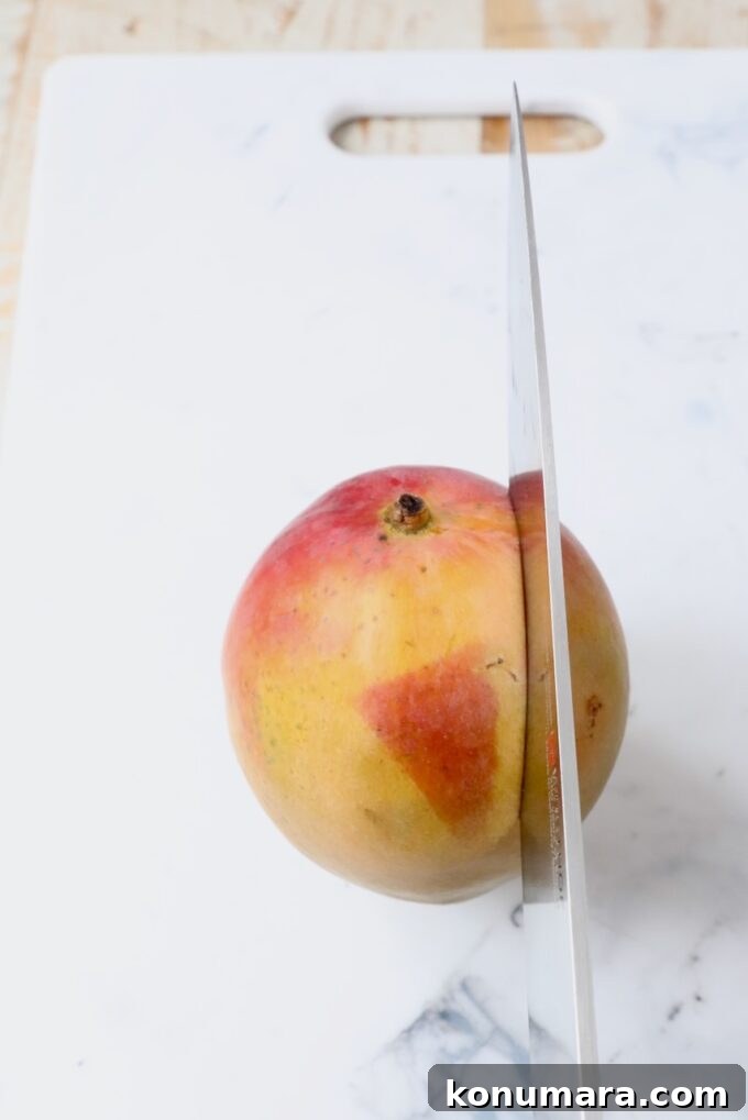 knife slicing through the side of a mango