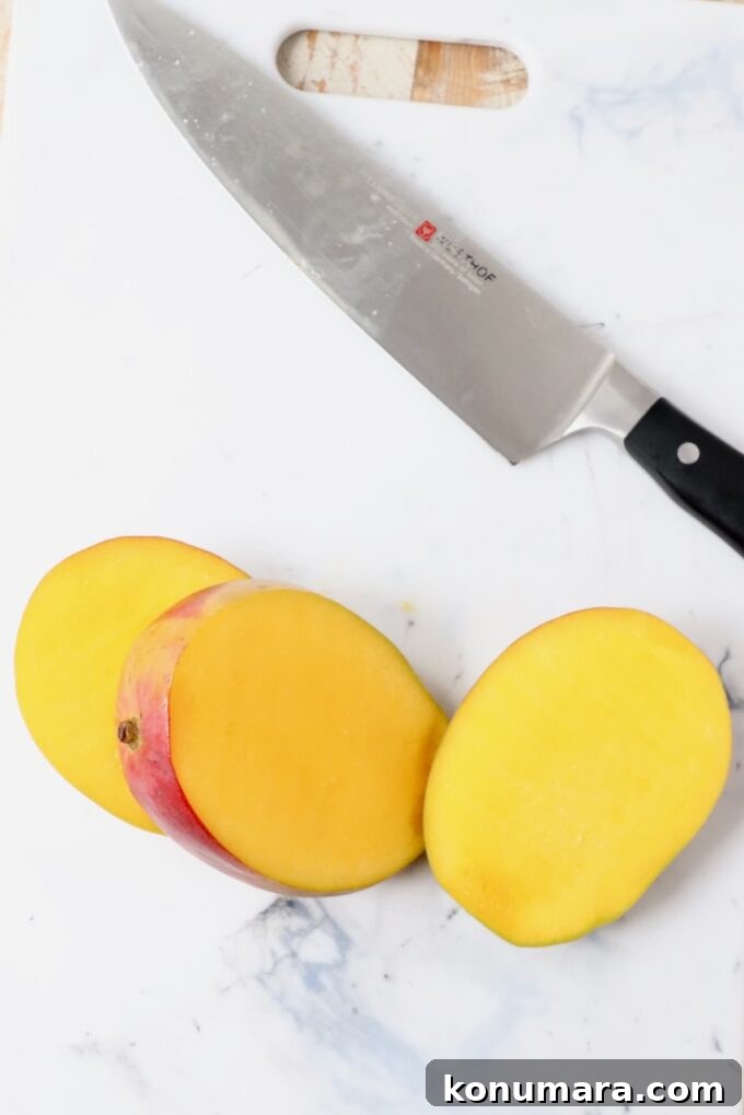 sliced mango on cutting board with knife