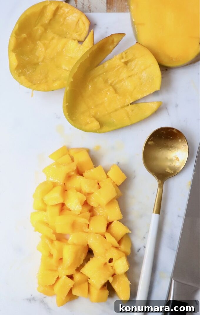 diced mango on cutting board with spoon