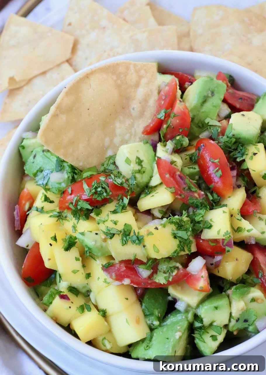 diced mango and avocado in bowl with tortilla chip