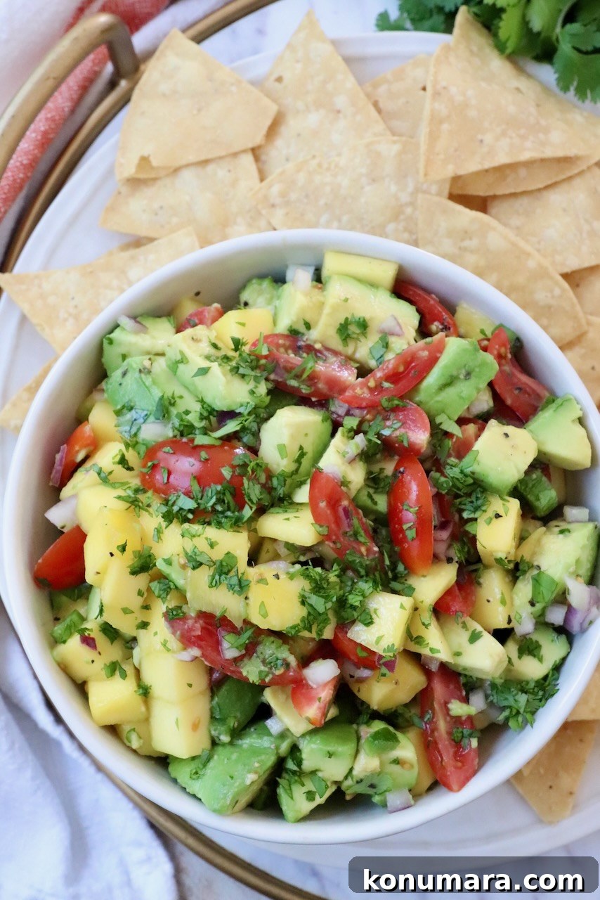 mango avocado salsa in bowl with tortilla chips around the bowl