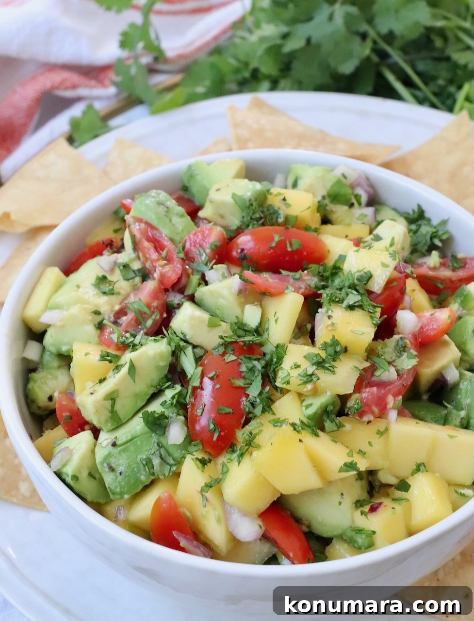 mango avocado salsa in bowl on tray with tortilla chips