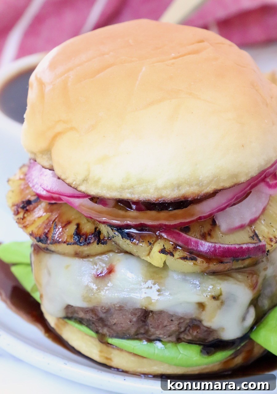 Hawaiian Burger with Grilled Pineapple and Teriyaki Sauce 8 cooked cheeseburger on plate with teriyaki sauce and grilled pineapple