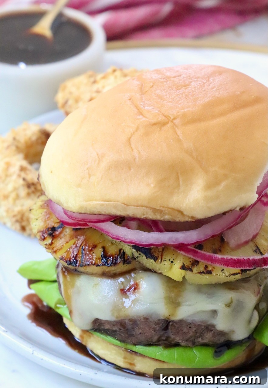Hawaiian Burger with Grilled Pineapple and Teriyaki Sauce 9 cooked cheeseburger on plate with a small bowl of teriyaki sauce