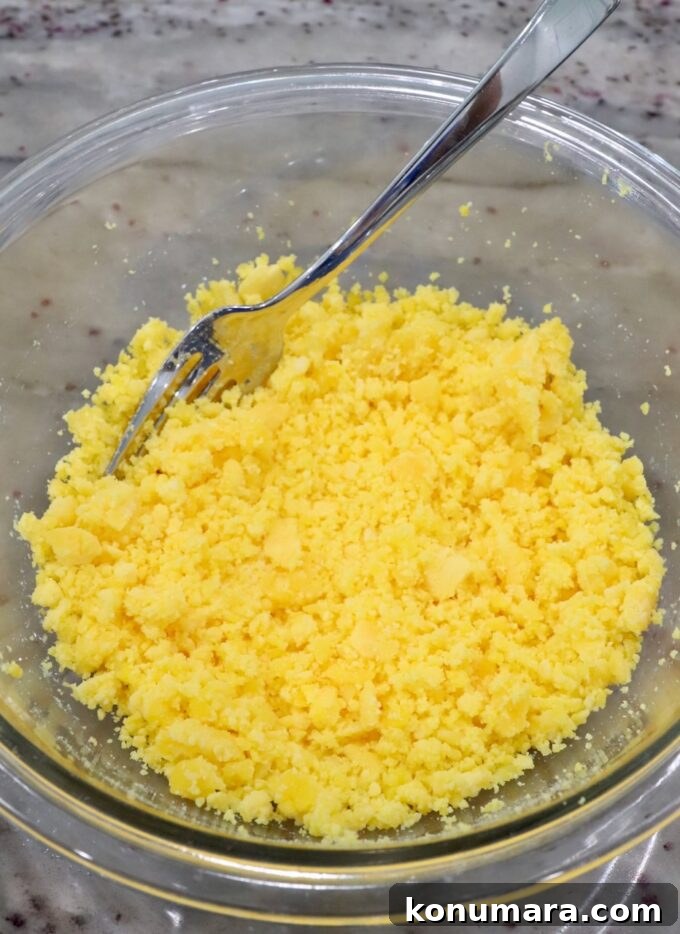mashed egg yolks in a glass bowl with a fork