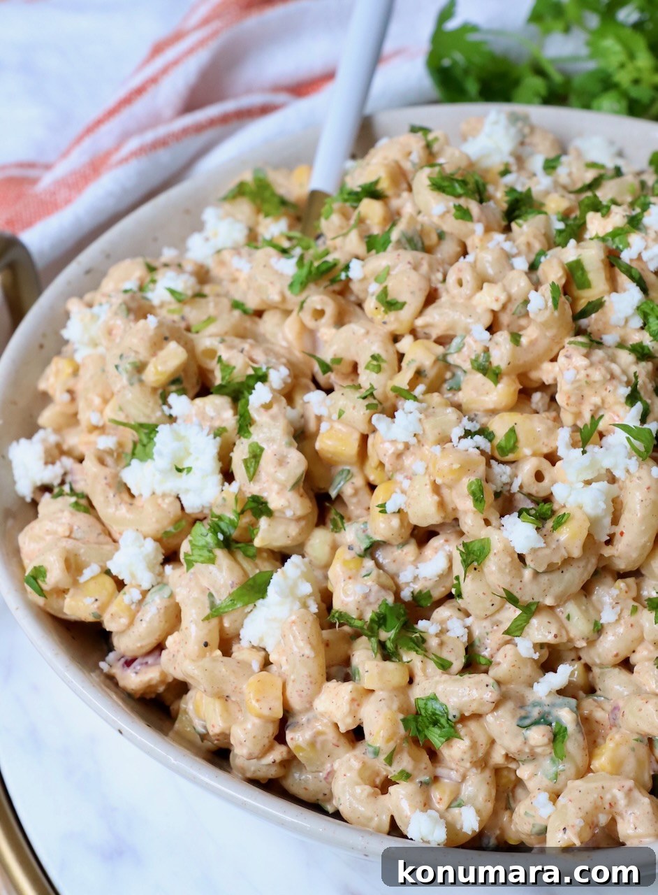 Elote Pasta Salad with Roasted Corn and Cotija 9 elote pasta salad in bowl with spoon