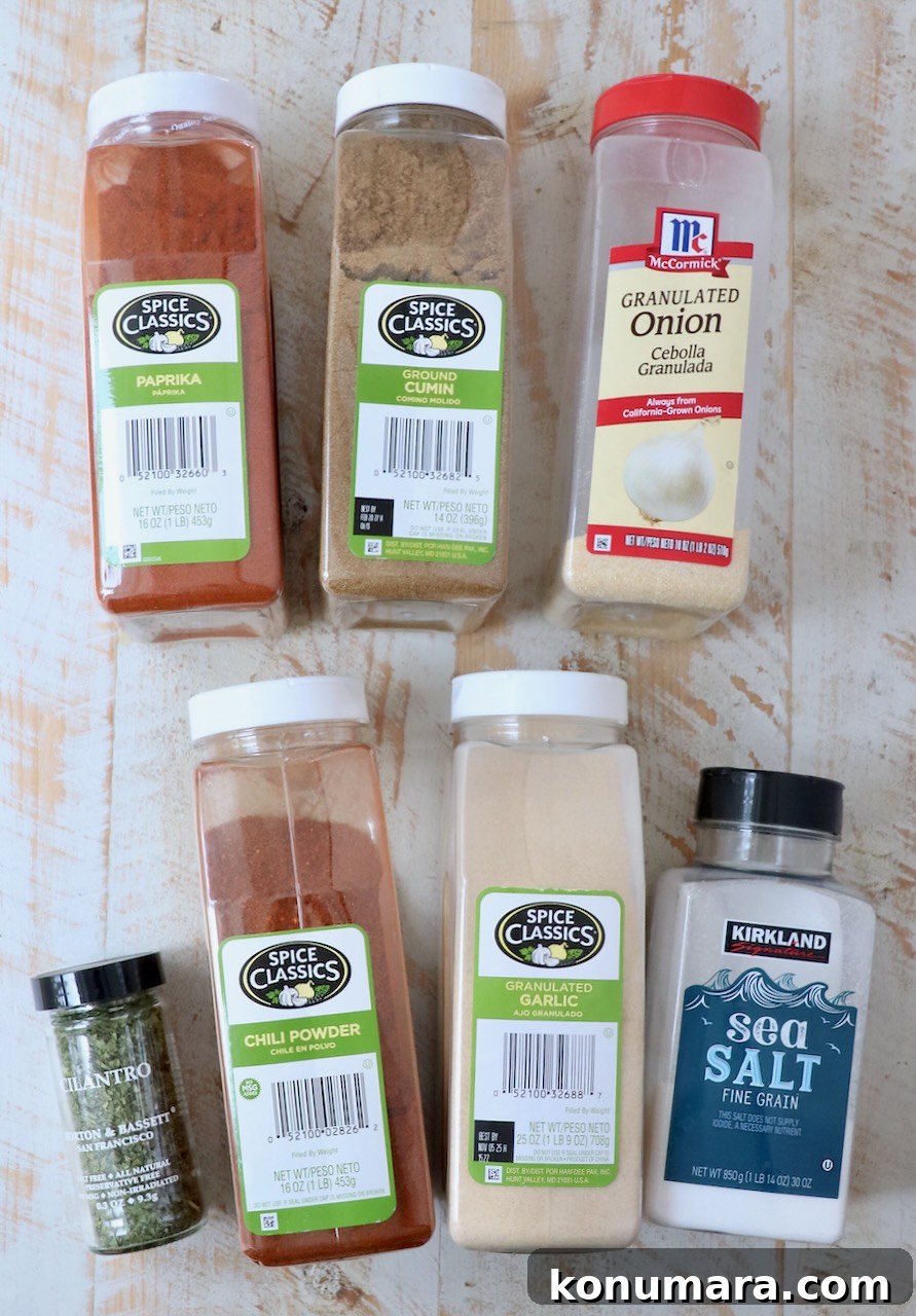 Authentic Carne Asada Seasoning for Tacos and Grilling 5 spices in plastic containers lined up on a white wood board
