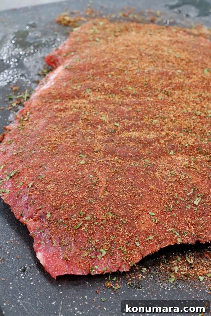 Authentic Carne Asada Seasoning for Tacos and Grilling 7 flank steak covered in seasoning on cutting board