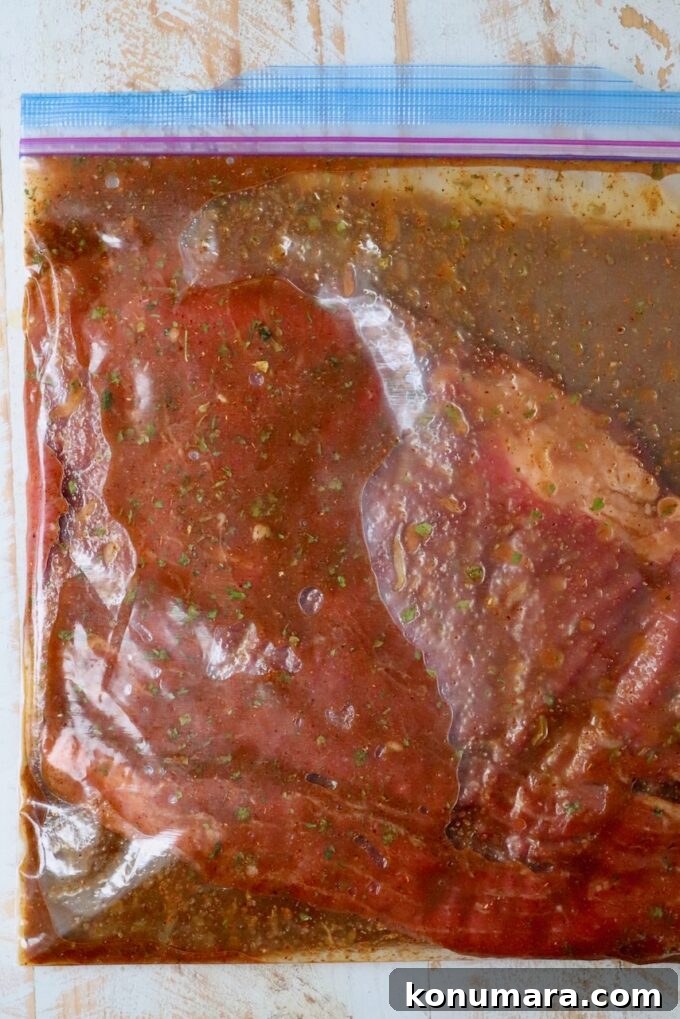 Authentic Carne Asada Seasoning for Tacos and Grilling 9 flank steak in bag of marinade on white wood board