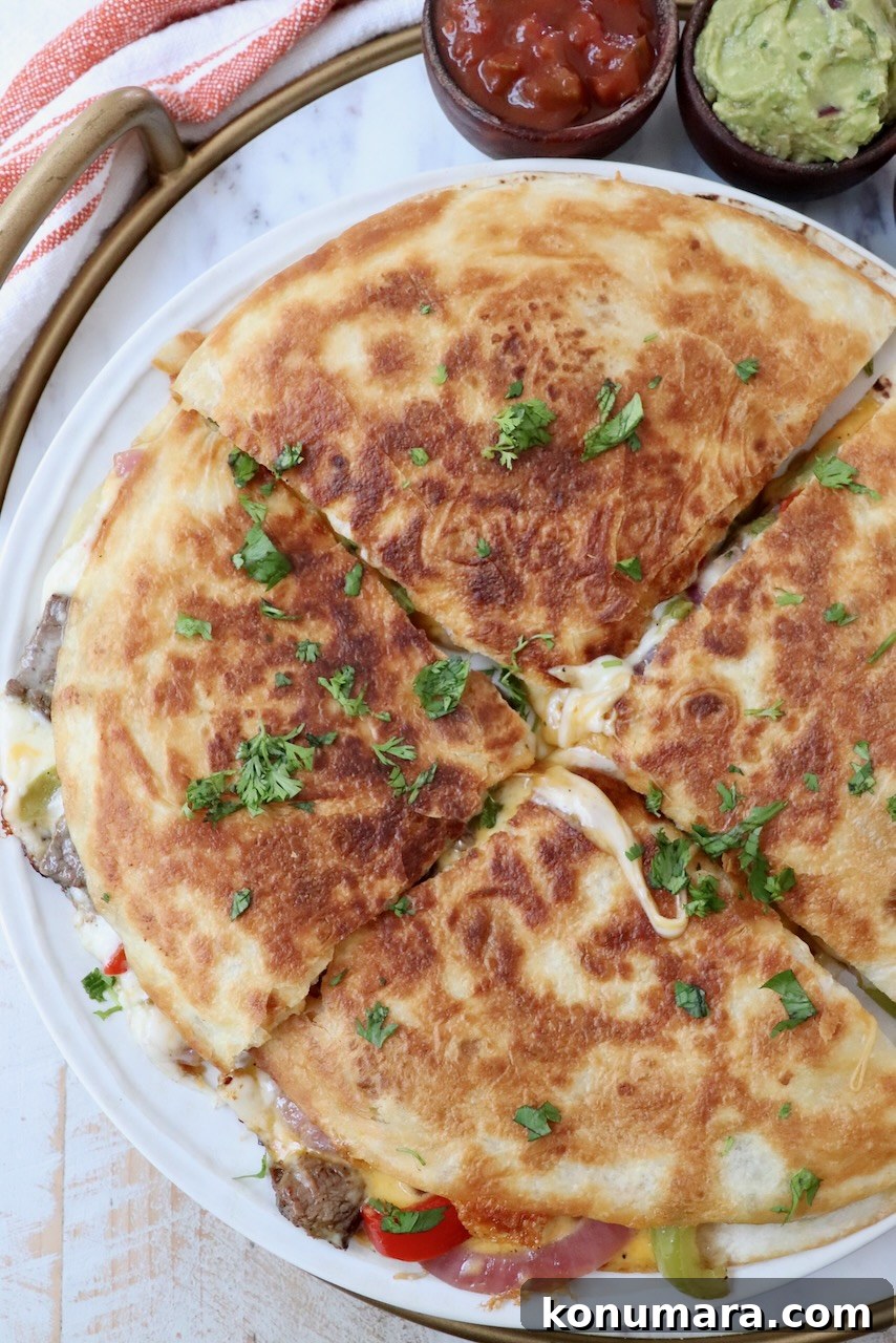Steak Quesadillas Recipe with Melted Cheese and Salsa 2 steak quesadilla on plate cut into four triangle pieces