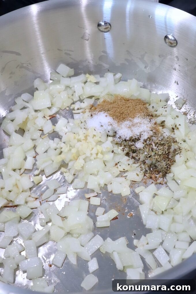 Smoky Chipotle Chicken Tinga Recipe 4 diced onions and garlic in pan with spices