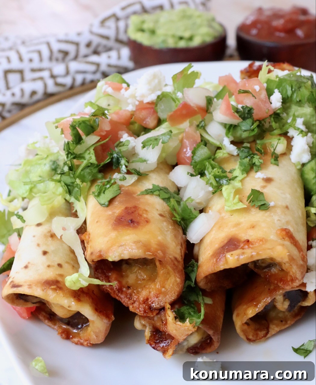 Homemade Crispy Beef Taquitos Recipe 11 cooked beef taquitos stacked up on a plate topped with pico de gallo