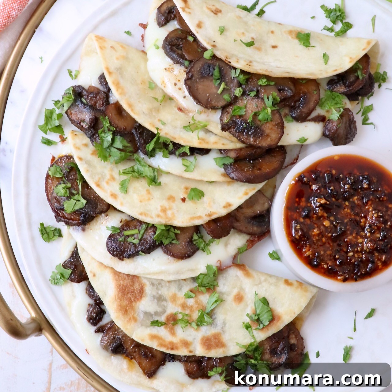 Flavorful Mushroom Tacos Recipe 2 Mushroom tacos stacked on a plate with a small bowl of salsa macha on the side