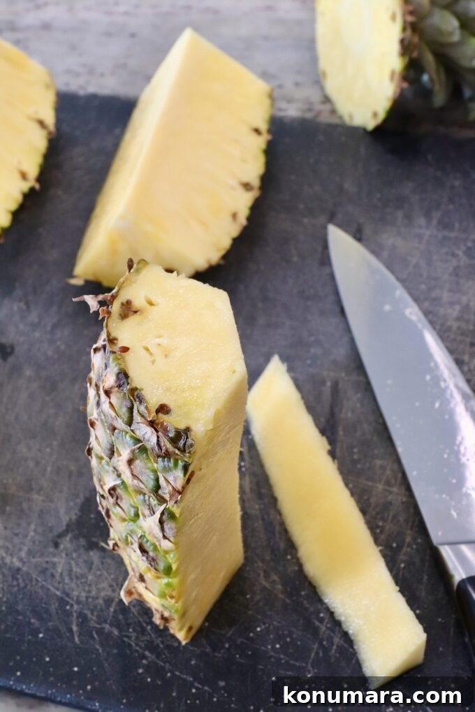 sliced pineapple on cutting board with the core removed