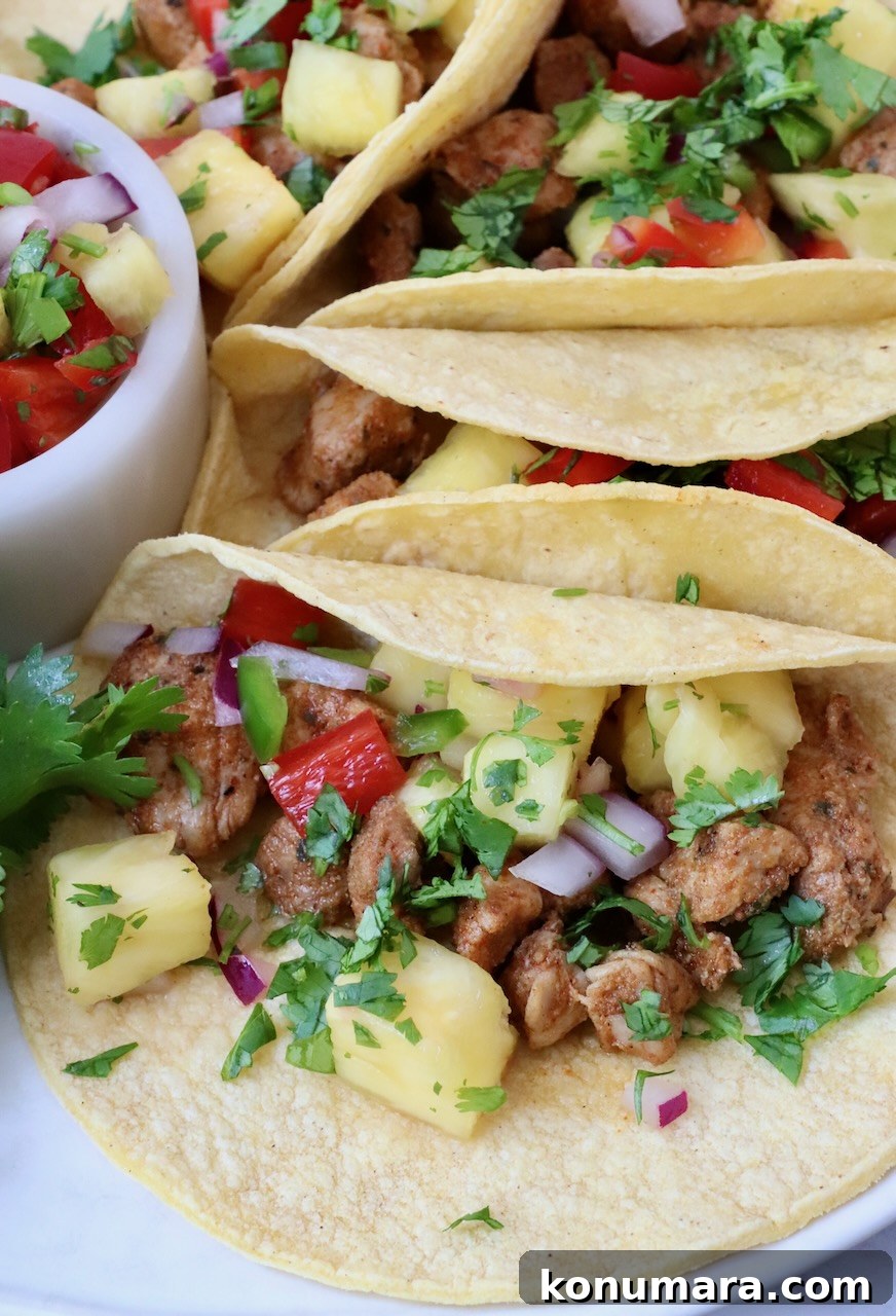 Homemade Carnitas Tacos Recipe with Salsa Verde 7 pork tacos topped with pineapple salsa on a plate