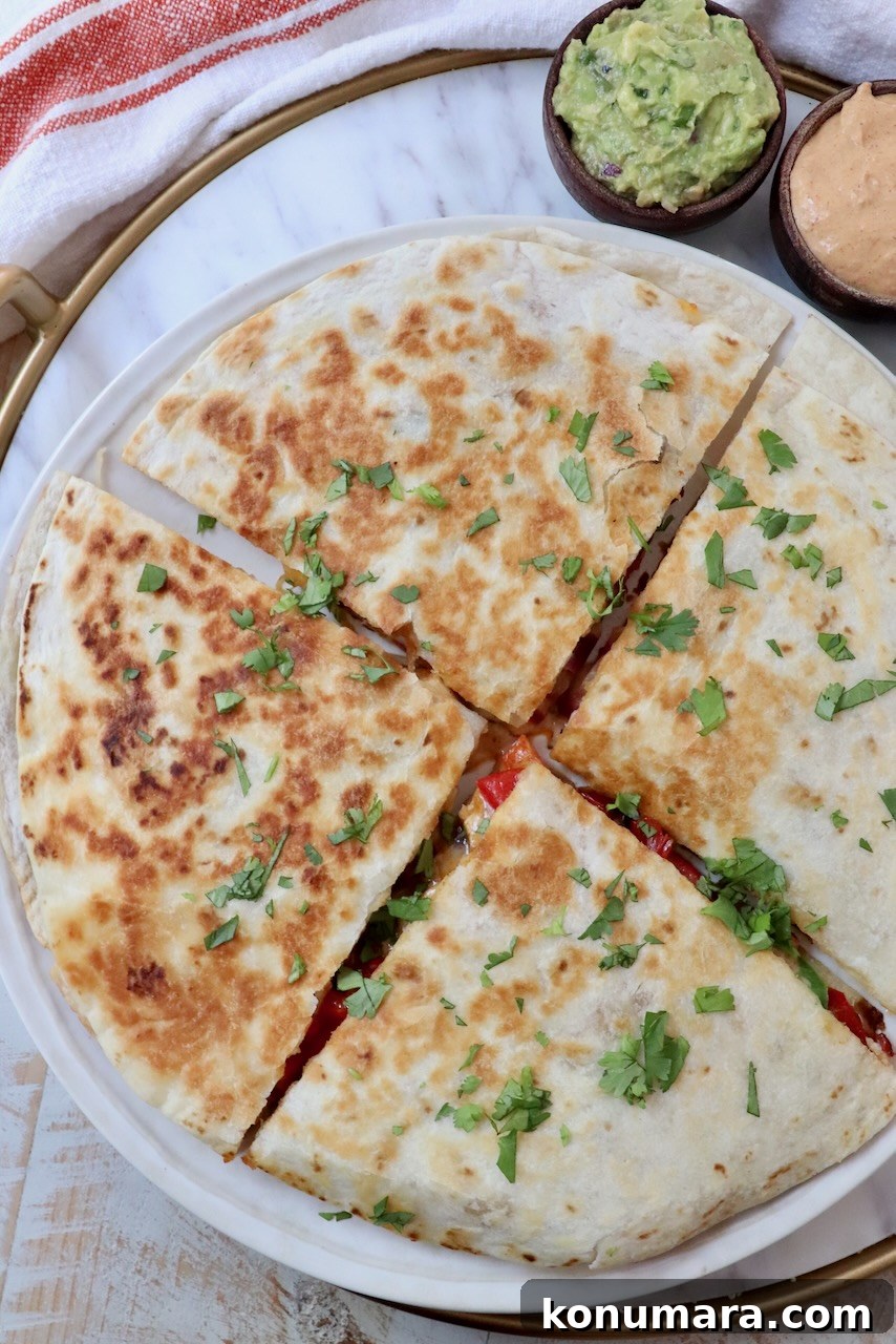 Crispy Chicken Quesadilla Recipe with Melty Cheese 2 chicken quesadilla sliced into quarters on a plate