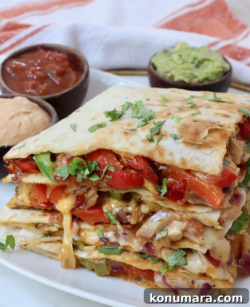 Crispy Chicken Quesadilla Recipe with Melty Cheese 7 stacked up chicken and fajita veggie quesadilla on a plate
