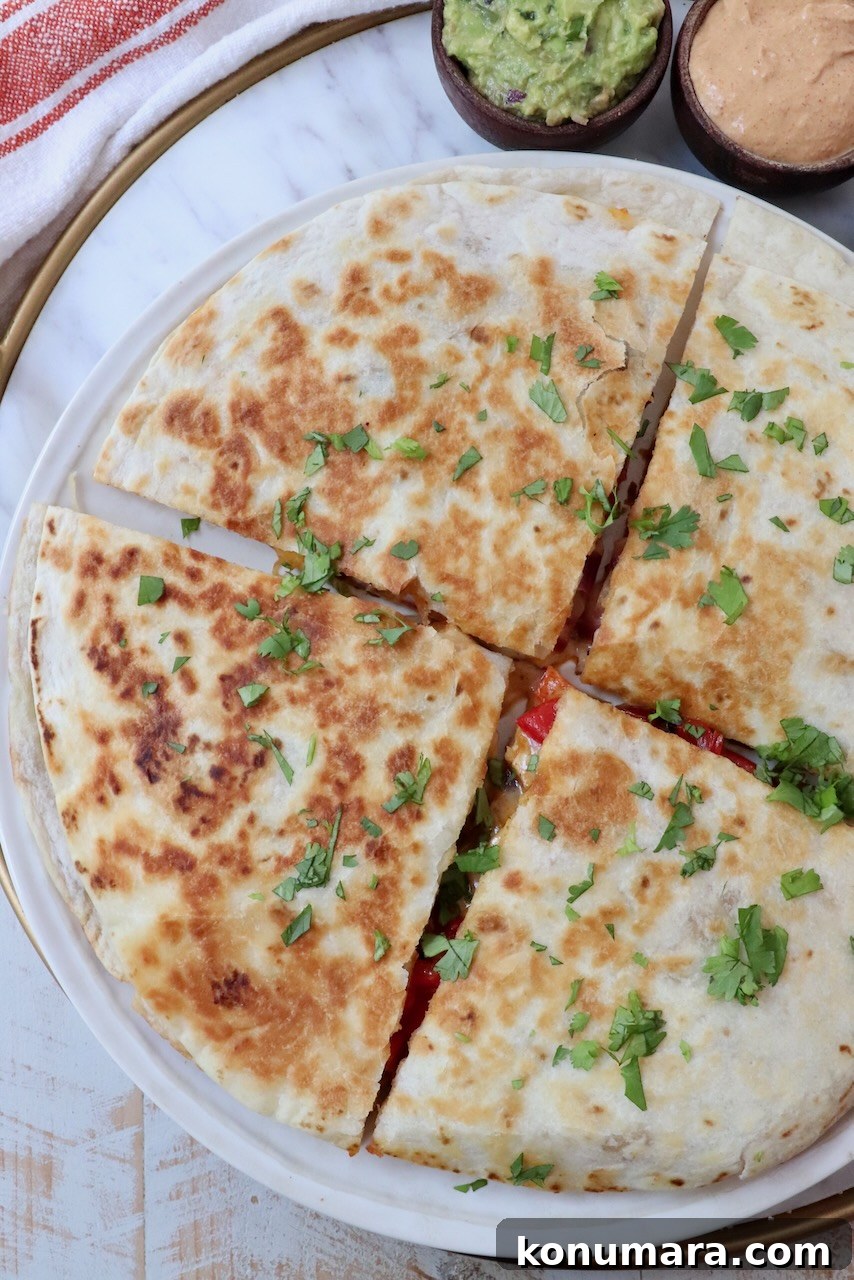 Crispy Chicken Quesadilla Recipe with Melty Cheese 8 chicken quesadilla sliced into quarters on a plate