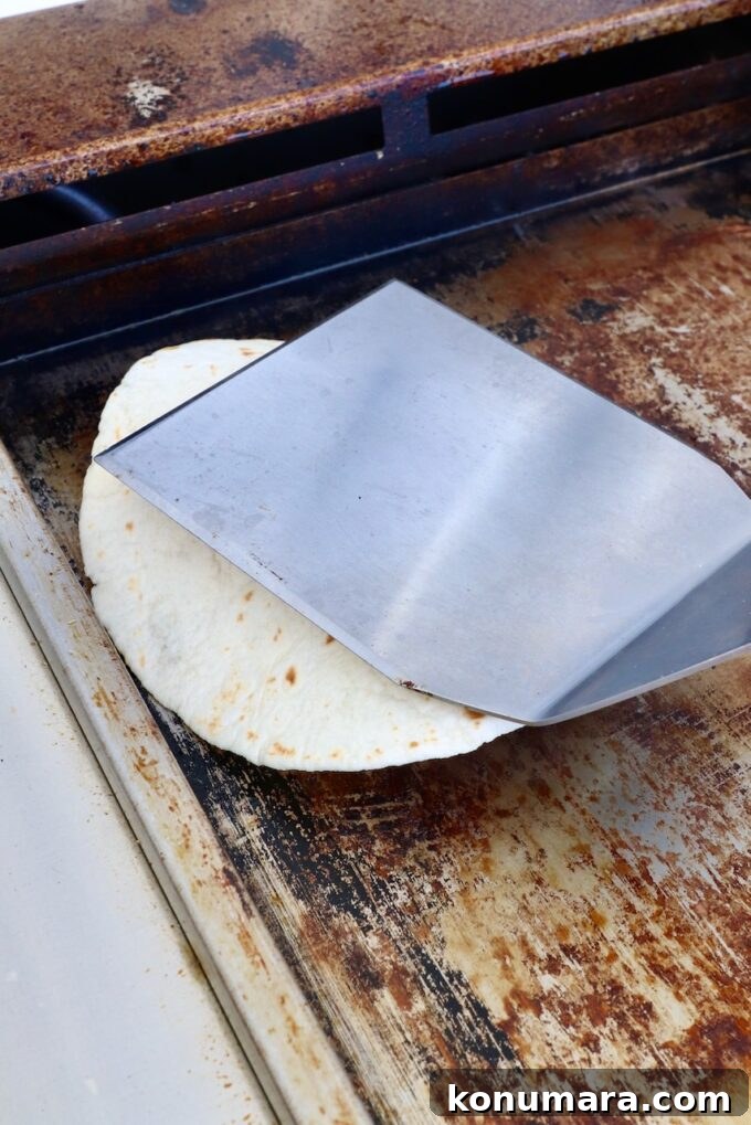 Smash Burger Taco Recipe: Crispy Smashed Patties 6 Spatula smashing a tortilla on a griddle