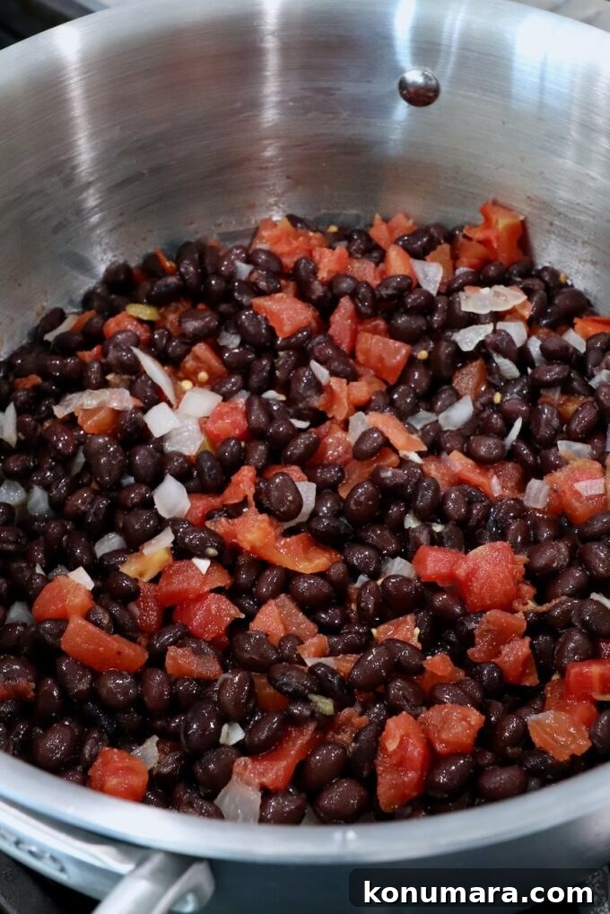 black beans, diced onions and tomatoes, in pot on the stove