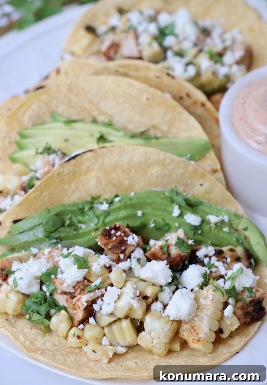 Elote Chicken Tacos with Mexican Street Corn 10 tacos on plate filled with diced chicken, corn and avocado