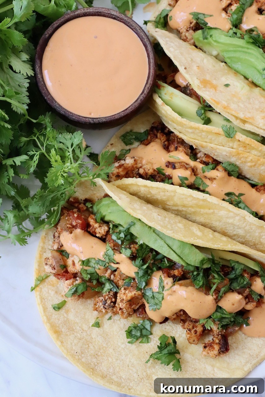 crumbled tofu tacos on plate topped with chipotle sauce