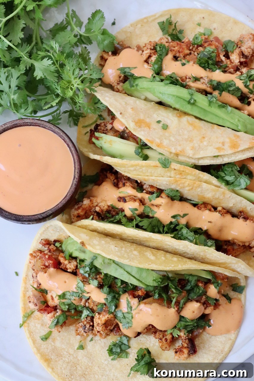 crumbled tofu tacos topped with chipotle sauce on a plate