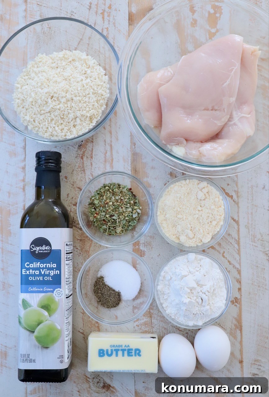 Crispy Parmesan-Crusted Chicken Recipe 3 ingredients for parmesan crusted chicken on white wood board